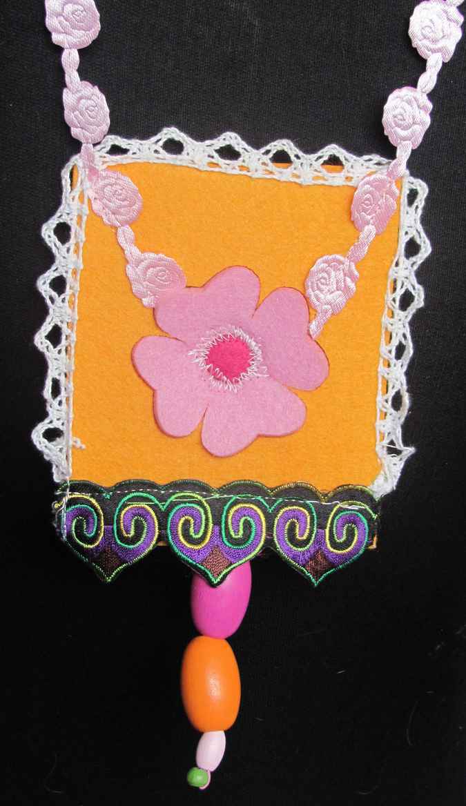 large image of art item: accessory – felt necklace with pink flower on yellow background