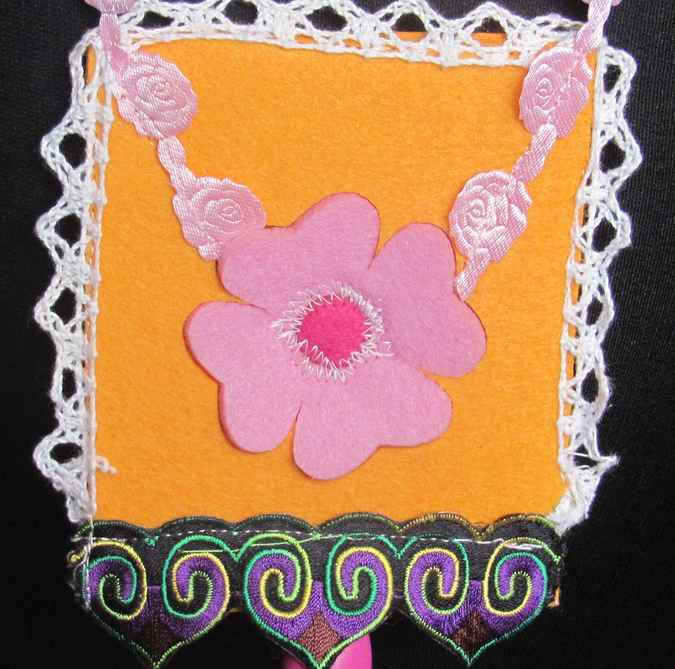 large image of art item: accessory – felt necklace with pink flower on yellow background