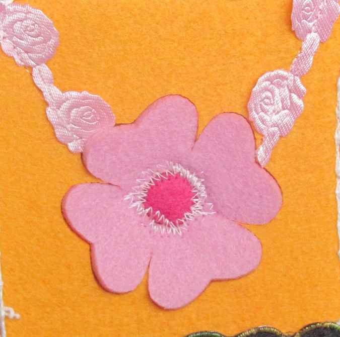 large image of art item: accessory – felt necklace with pink flower on yellow background