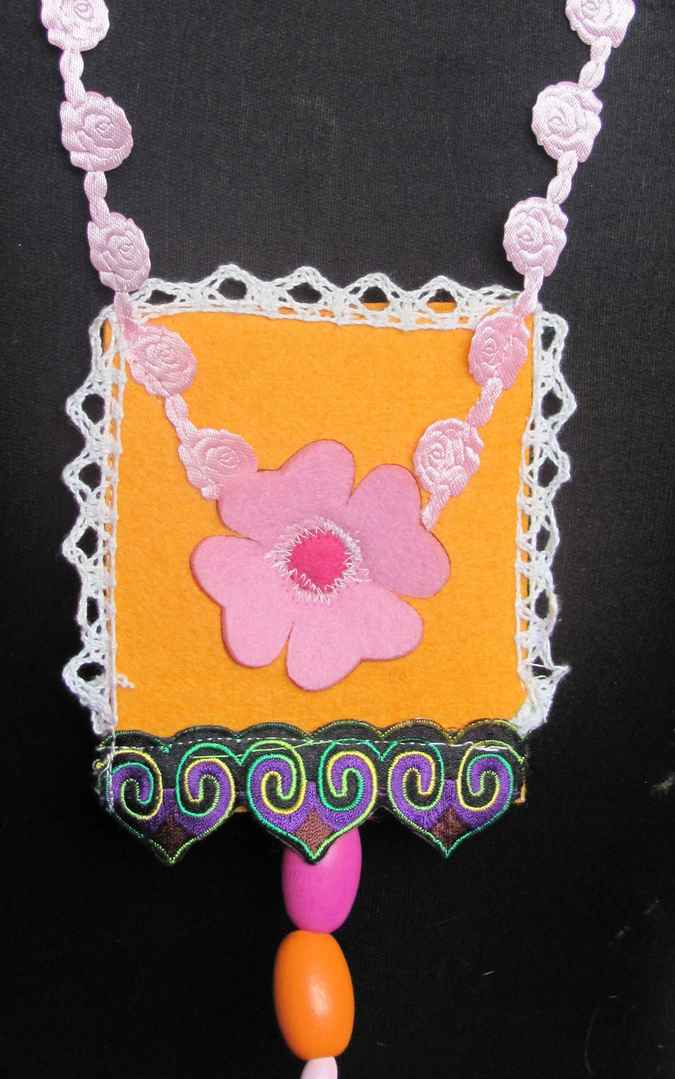 large image of art item: accessory – felt necklace with pink flower on yellow background